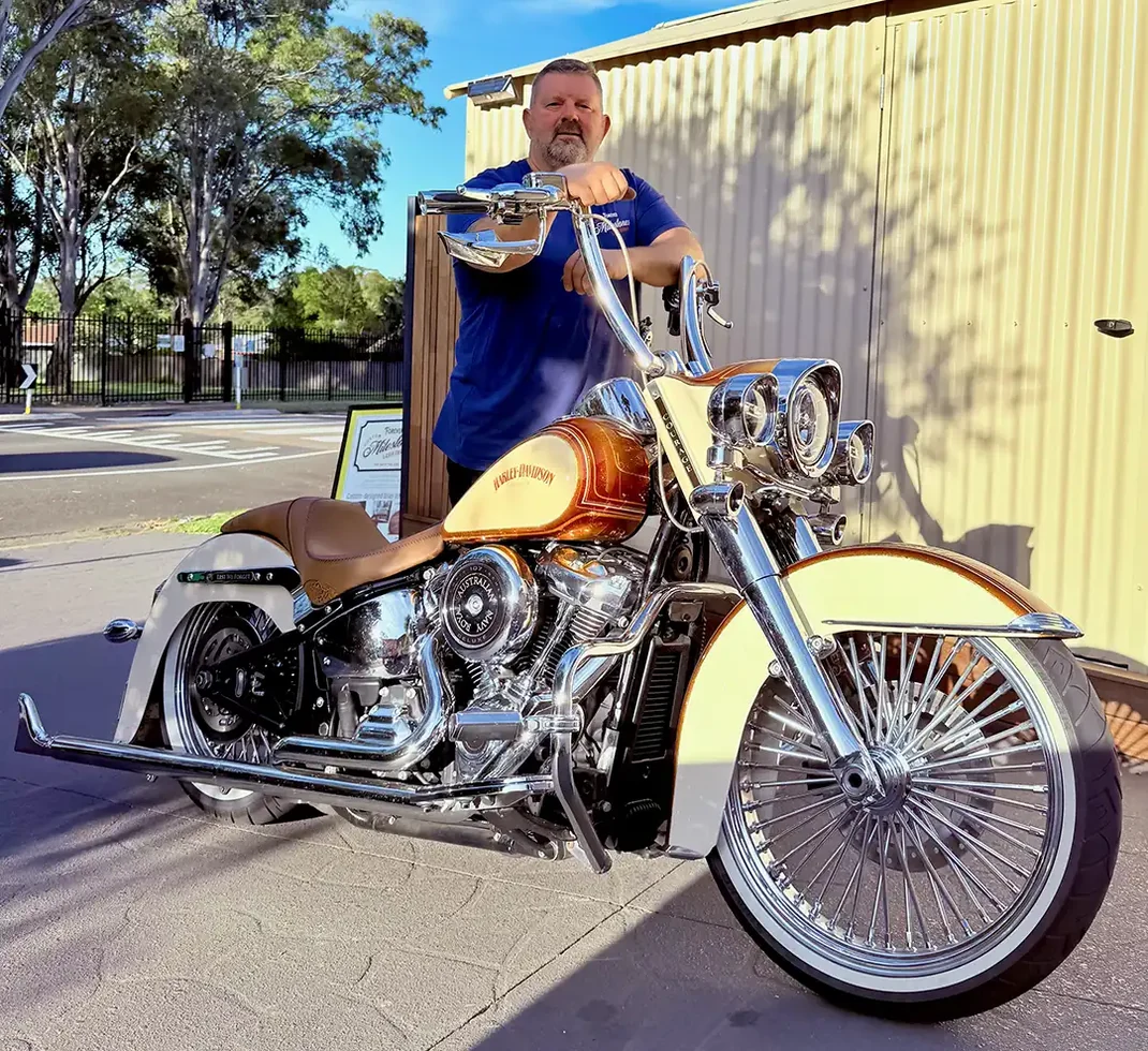 Phil Taylor standing with his custom Harley-Davidson motorcycle